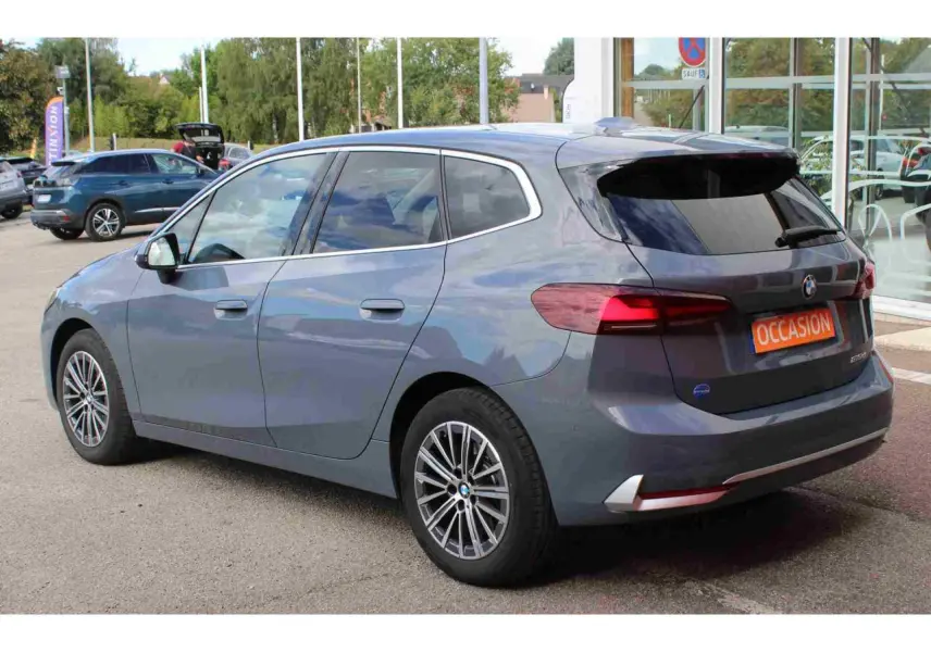 BMW Série 2 Active Tourer gris vue 3/4 arrière droit, feux arrière LED et jantes alliage 17 pouces visibles.