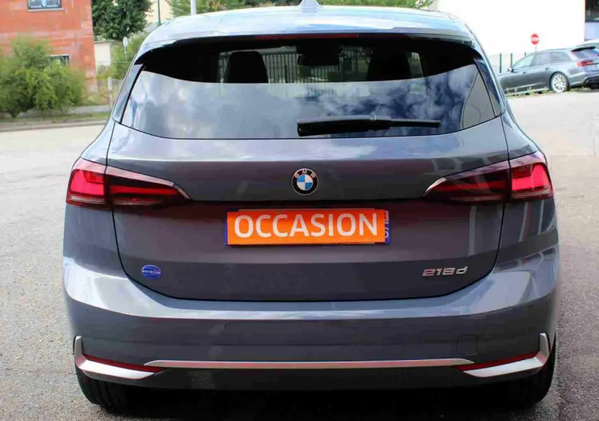 Vue arrière d’une BMW Série 2 Active Tourer grise 218d avec feux arrière LED et plaque orange « Occasion » visible.
