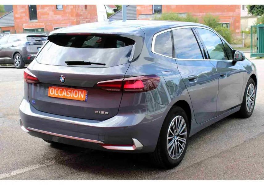 BMW Série 2 Active Tourer gris vue 3/4 arrière droit avec feux arrière LED et jantes alliage 17 pouces.