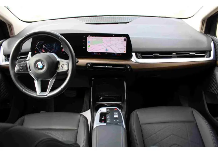 Vue intérieure avant du tableau de bord de la BMW Série 2 Active Tourer gris avec écran tactile incurvé et volant cuir multifonctions.