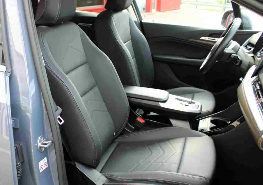Vue intérieure côté gauche de la BMW Série 2 Active Tourer 2023, sièges simili cuir noirs et console centrale avec accoudoir.