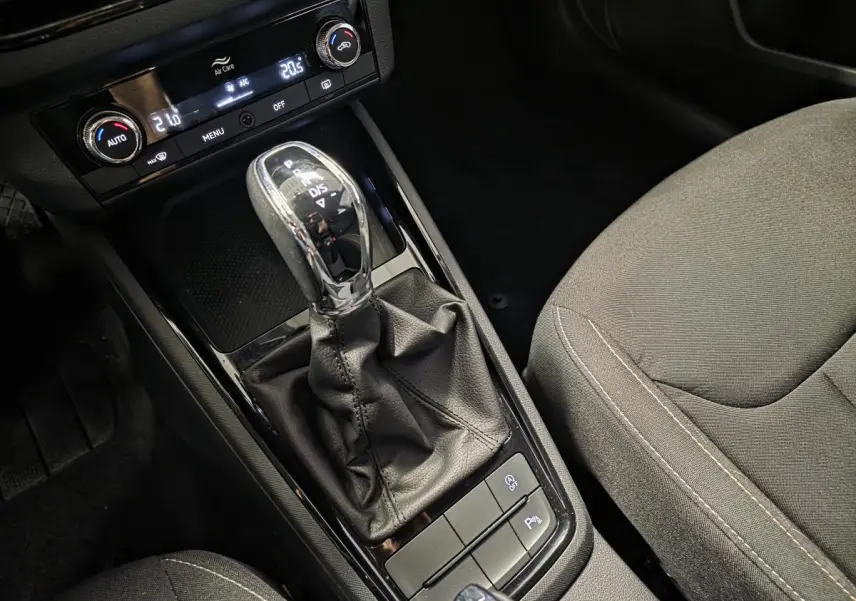 Gros plan sur la console centrale intérieure du Skoda Kamiq 2023, mettant en valeur le levier de vitesses automatique et les commandes de climatisation.