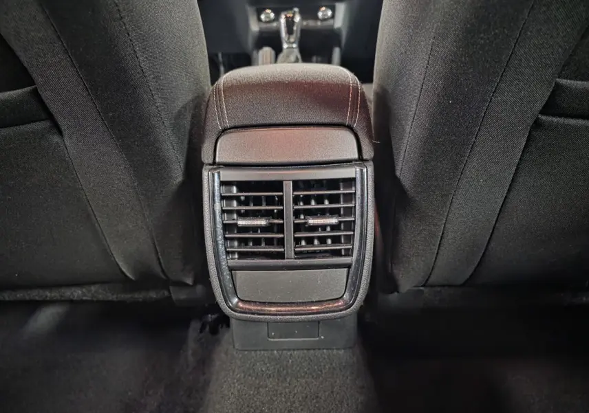 Vue rapprochée des aérateurs arrière et accoudoir central noir entre les sièges avant d’un Skoda Kamiq 2023.