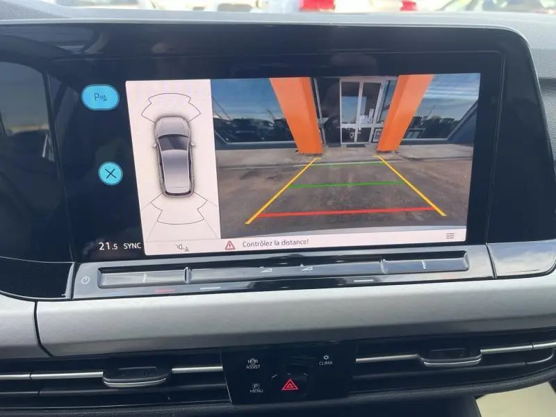 Écran tactile intérieur de la Volkswagen Golf 1.5 eTSI montrant la caméra de recul avec lignes de guidage colorées.