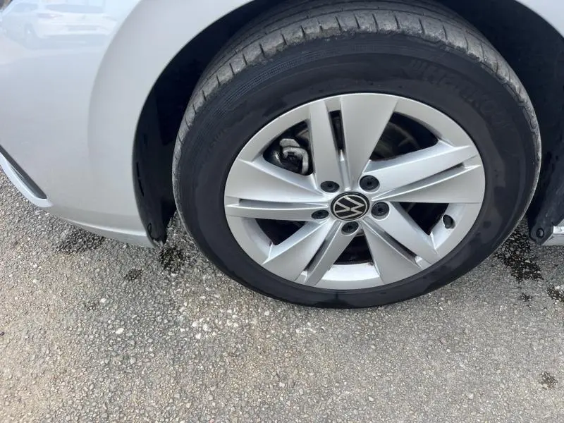 Gros plan sur la roue avant gauche argentée avec jante alu Volkswagen d'une Golf Reflet d'Argent métallisée.
