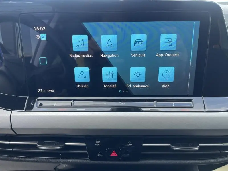 Écran tactile central du tableau de bord d'une Volkswagen Golf 1.5 eTSI argentée, affichant le menu multimédia.