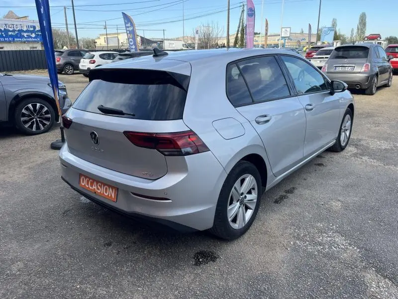 Volkswagen Golf 1.5 eTSI 150ch Life Business en Reflet d'Argent, vue 3/4 arrière droit sur parking.