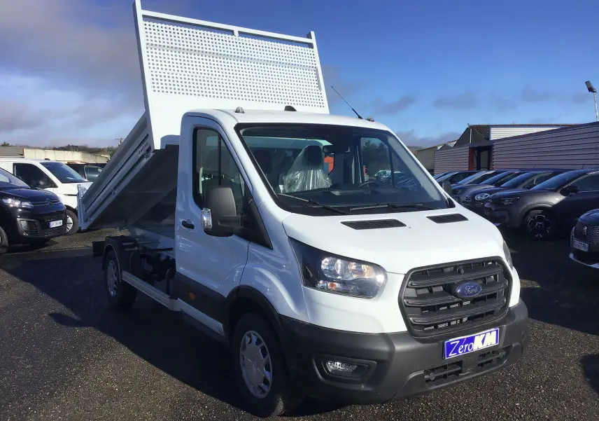 Vue 3/4 avant gauche d'un Ford Transit Chassis Cabine blanc avec benne relevée sur un parking.