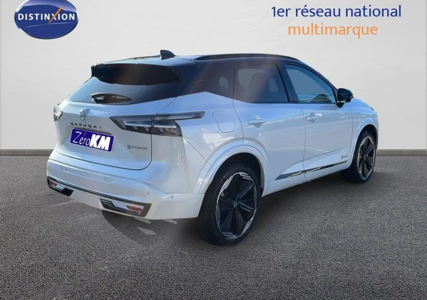 Nissan Qashqai blanc nacré toit noir en 3/4 arrière droit, jantes noires et feux arrière LED distinctifs.