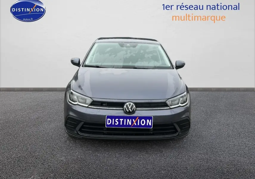 Vue frontale d'une Volkswagen Polo gris cendre 2025 avec calandre noire et phares LED allumés.