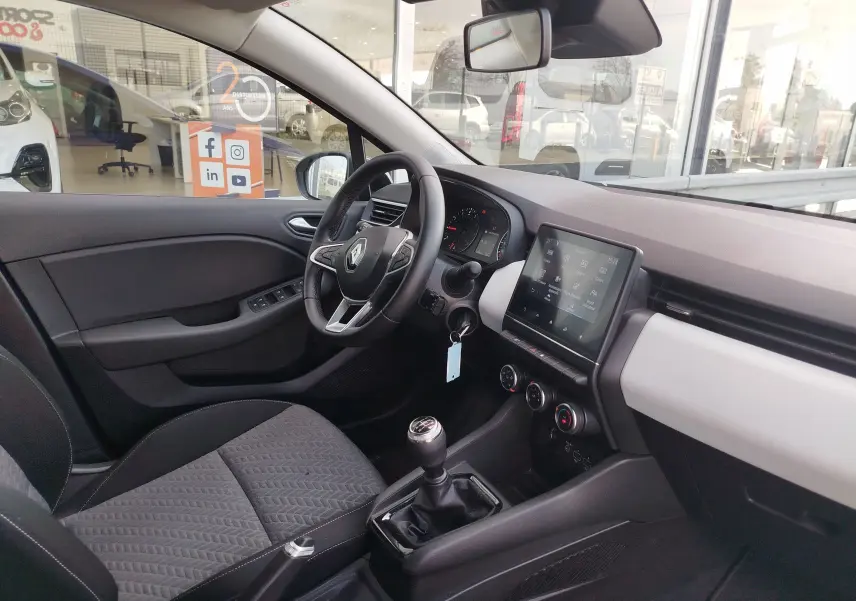 Intérieur de Renault Clio 1.0 SCe 65ch Evolution 2022 vu côté conducteur, tableau de bord moderne avec écran tactile et boîte manuelle.