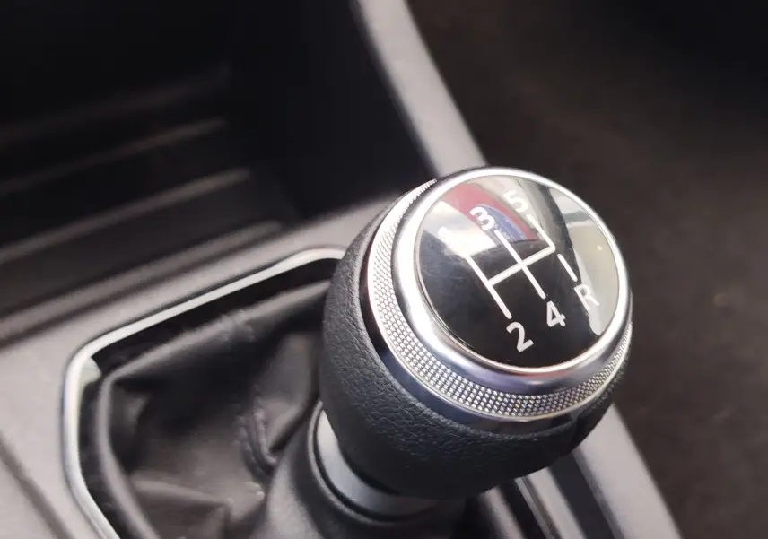 Gros plan sur le levier de vitesses manuel d’une Renault Clio 2022, intérieur noir avec coutures visibles.