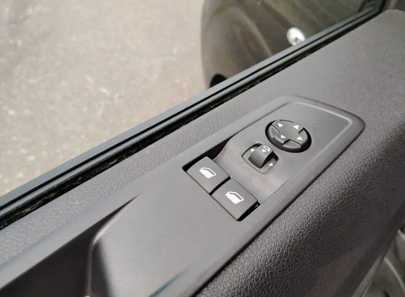 Gros plan sur les commandes électriques des vitres et rétroviseurs côté conducteur du Citroën Jumpy Cabine Approfondie gris titane.