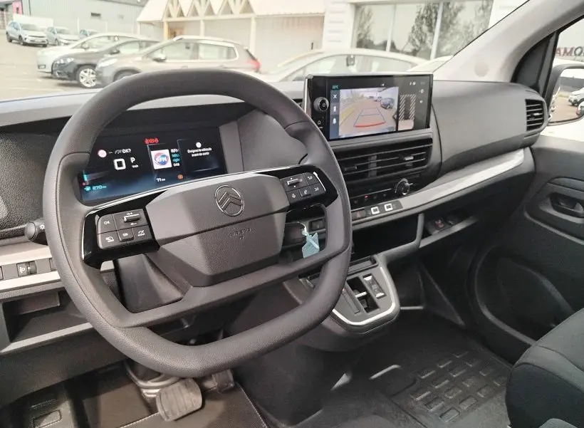 Intérieur du Citroën Jumpy Cabine Approfondie 2025, vue tableau de bord avec volant multifonction et écran caméra de recul.