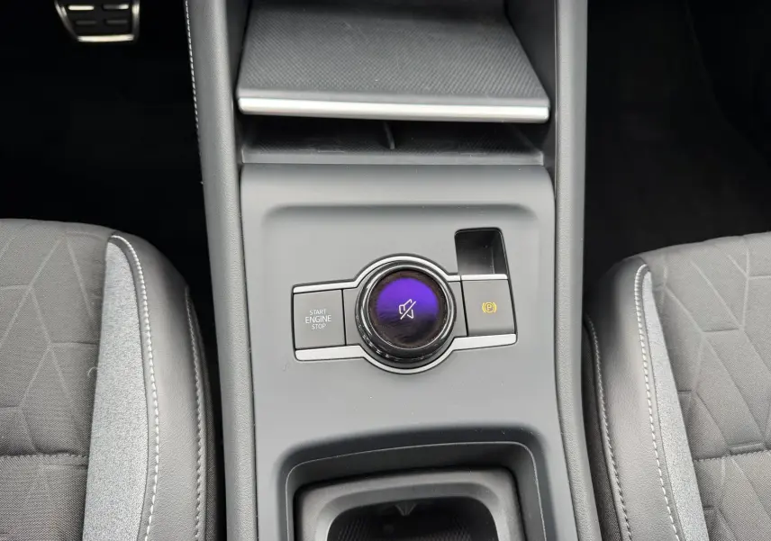 Vue rapprochée du console central du Volkswagen Tiguan 2025 montrant la molette de commande et les sièges gris.