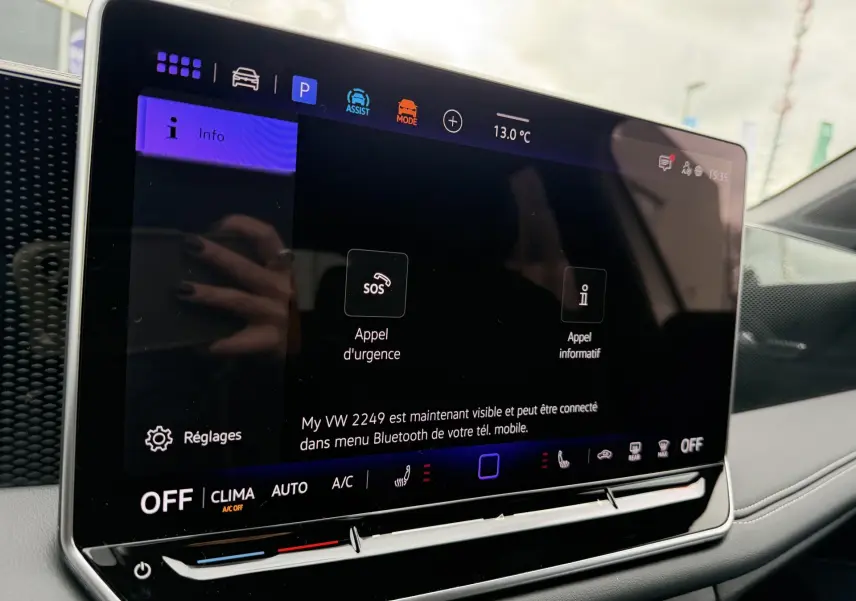 Écran tactile central du Volkswagen Tiguan 2025 montrant les options d'appel d'urgence et réglages, intérieur gris.