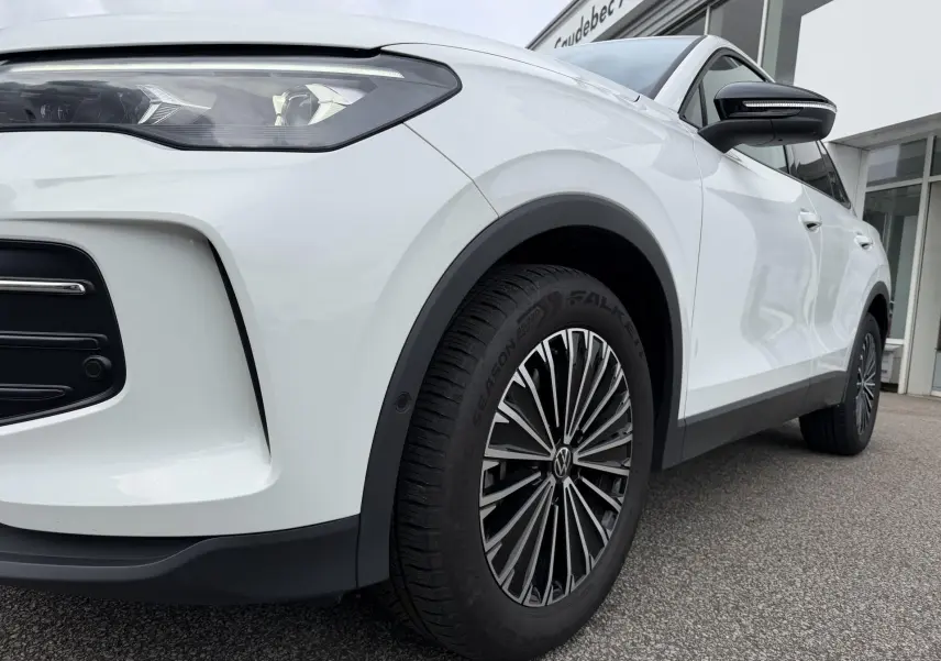 Vue en 3/4 avant droit d’un Volkswagen Tiguan blanc, mettant en valeur le phare Matrix HD et la jante alliage distinctive.