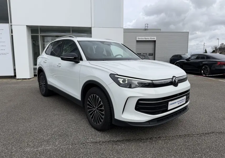 Volkswagen Tiguan blanc vu en 3/4 avant droit, avec projecteurs Matrix HD et jantes noires distinctives.