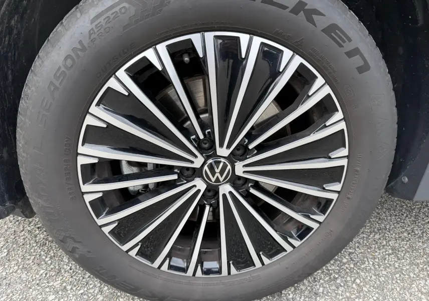 Gros plan sur la jante noire et argentée d’un Volkswagen Tiguan 2025 avec logo VW au centre et pneu Falken.