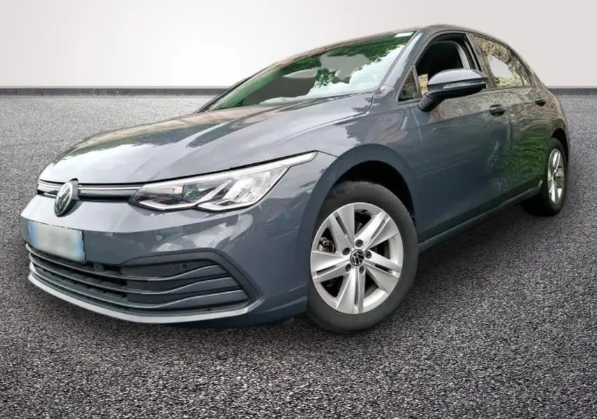 Volkswagen Golf gris clair vue 3/4 avant droit, avec jantes alliage et phares LED allumés.
