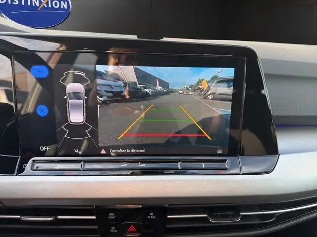 Écran tactile central montrant la caméra de recul avec guidage coloré dans une Volkswagen Golf gris clair 2023.