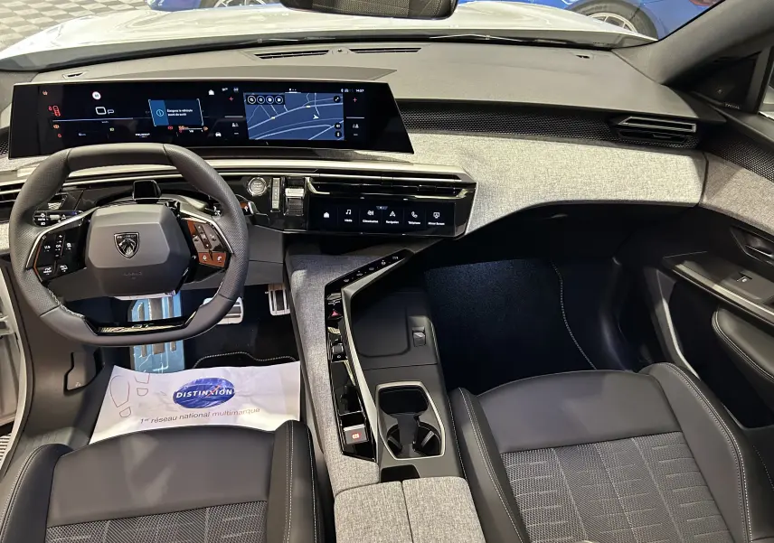 Vue intérieure avant du Peugeot 3008 Hybrid blanc Okenite, avec tableau de bord numérique panoramique et sellerie noire.