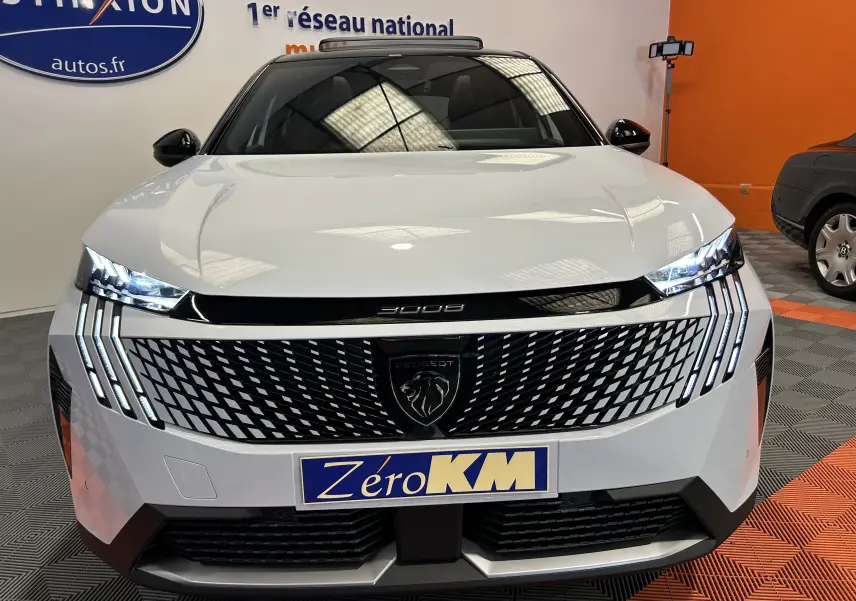 Vue avant d'un Peugeot 3008 blanc Okenite avec calandre noire à motif géométrique et phares LED allumés.
