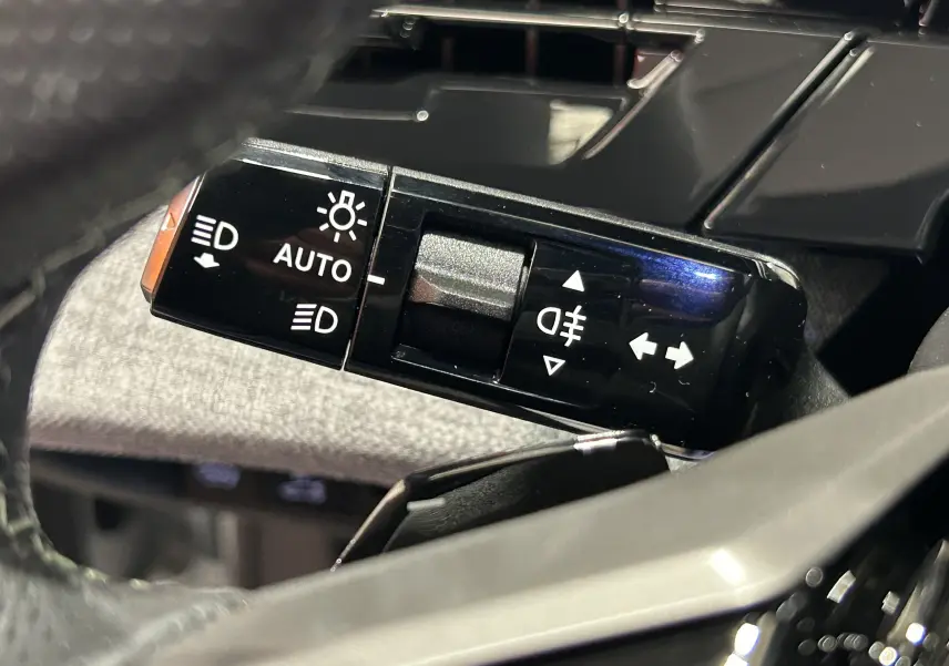 Gros plan sur la commande des feux et clignotants dans l’habitacle du Peugeot 3008 blanc Okenite 2026.