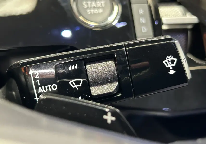 Gros plan sur la commande des essuie-glaces et bouton start du Peugeot 3008 III Hybrid blanc, intérieur noir brillant.