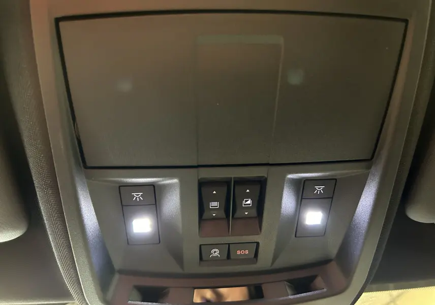 Vue rapprochée du plafonnier noir avec boutons d’éclairage et alerte SOS dans un Peugeot 3008 blanc Okenite.