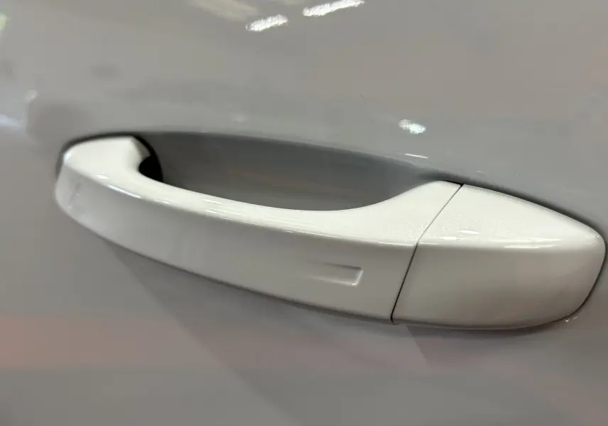 Poignée de porte blanche vue de près sur un Peugeot 3008 III Hybrid 145ch e-DCS6 GT blanc Okenite.