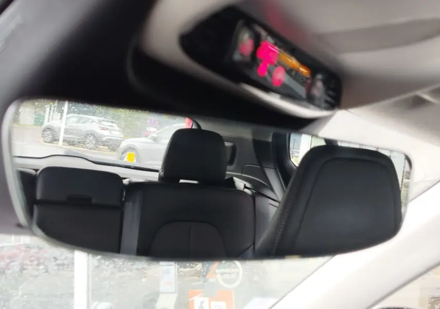 Reflet dans le rétroviseur intérieur montrant les sièges arrière en cuir noir du Volvo XC40 beige de 2020.