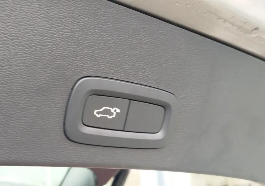 Bouton d'ouverture électrique du coffre sur la garniture intérieure beige du Volvo XC40 D3 2020.