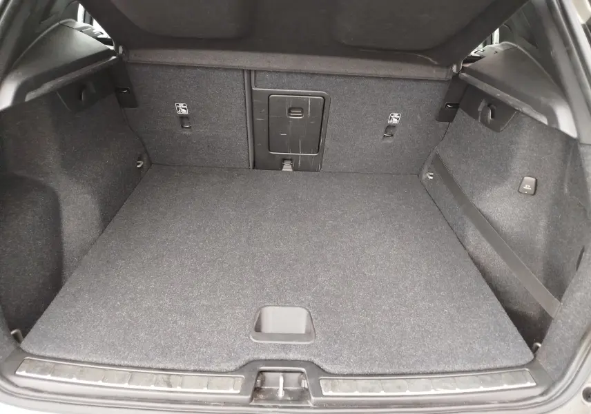 Coffre ouvert du Volvo XC40 beige 2020, vue de l'arrière montrant un espace de chargement propre et bien agencé.
