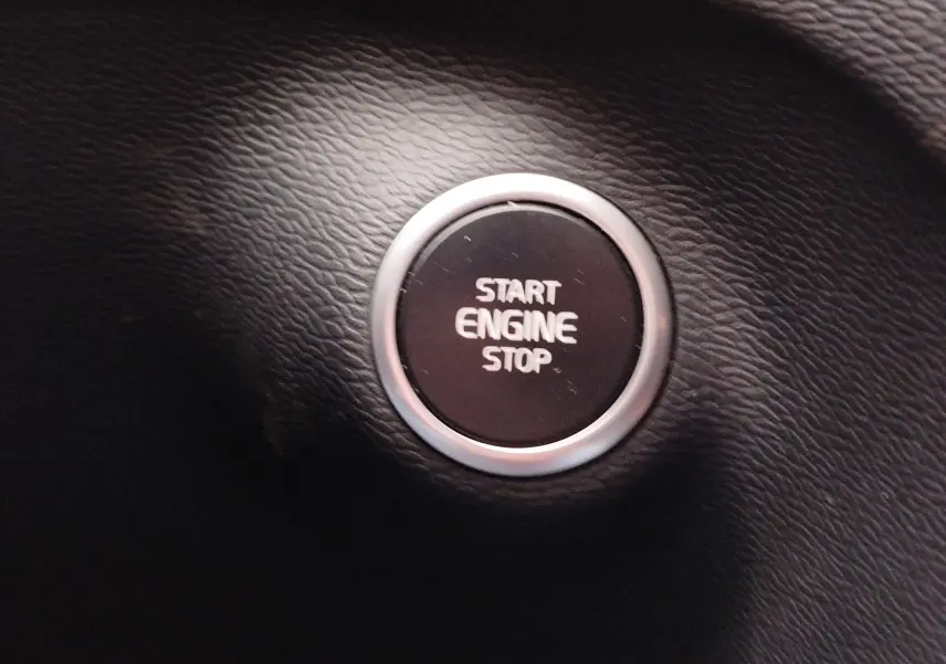 Bouton rond noir "Start Engine Stop" sur tableau de bord en cuir noir du Volvo XC40 beige 2020.