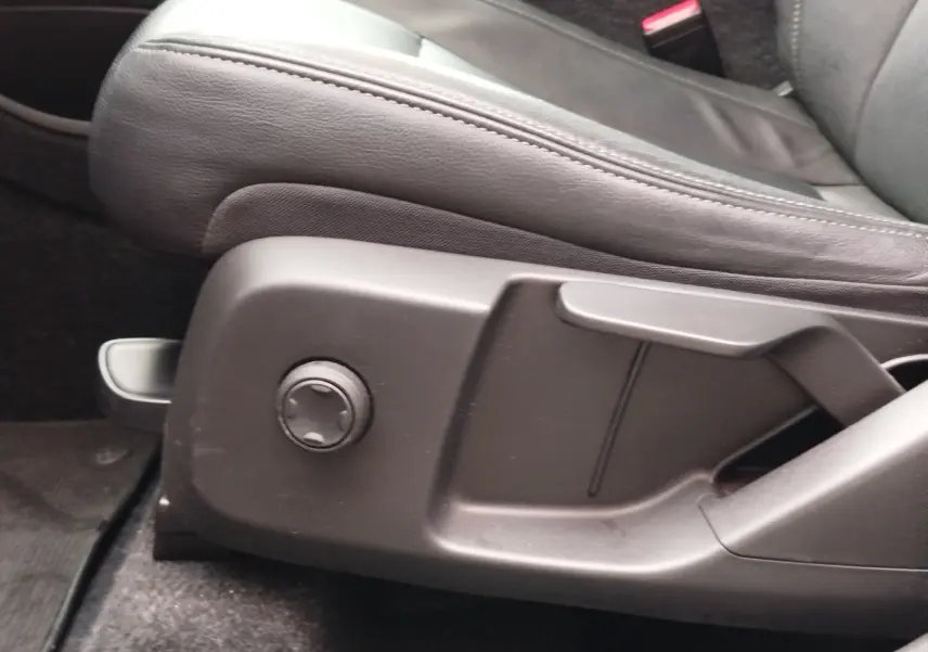Gros plan sur la commande de réglage du siège conducteur en cuir noir du Volvo XC40 beige, version D3 2020.