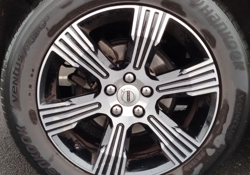 Gros plan sur la jante alliage bicolore noire et argentée d’un Volvo XC40 beige, avec pneu Hankook Ventus Prime 4.