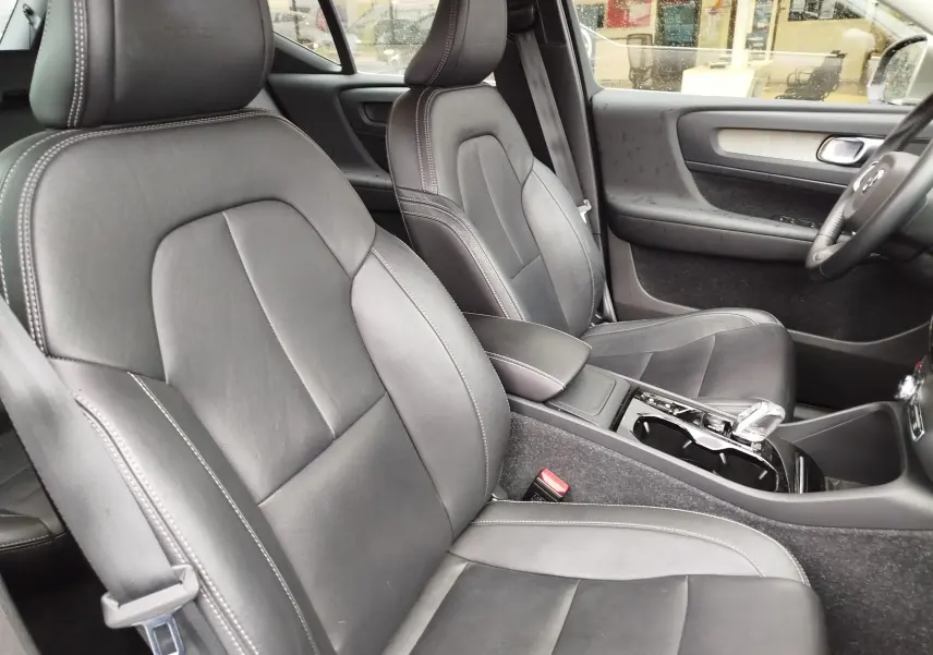 Vue intérieure côté droit du Volvo XC40 beige 2020, montrant les sièges avant en cuir noir et la console centrale.
