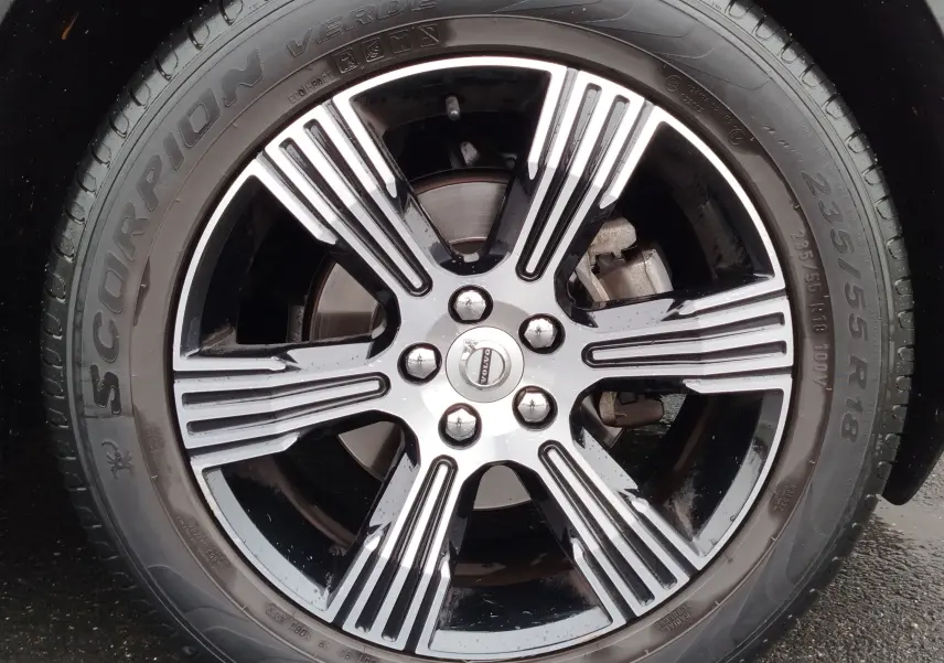 Gros plan sur la jante bi-ton noire et argentée d’un Volvo XC40 beige, avec pneu Pirelli Scorpion Verde.