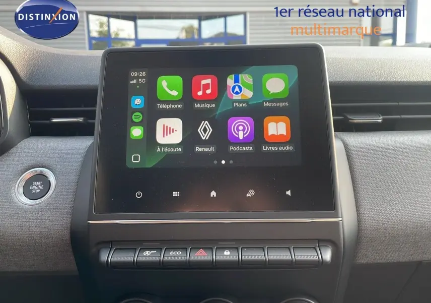 Écran tactile central allumé dans l'habitacle gris d'une Renault Clio 1.5 DCI 2025, avec bouton start engine visible.