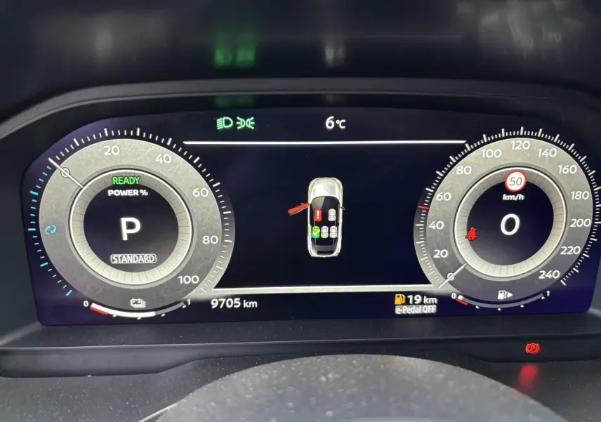 Affichage numérique du tableau de bord du Nissan Qashqai blanc nacré, montrant la vitesse, la température et l'état du véhicule.