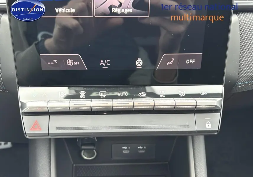 Gros plan sur la console centrale tactile et les commandes climatisation du Renault Captur gris rafale 2025.