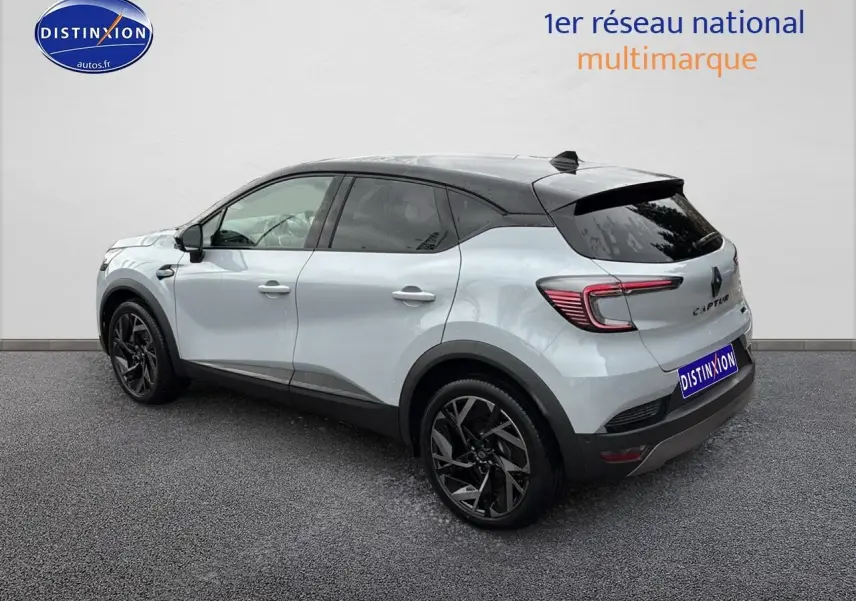 Renault Captur 2025 gris rafale et noir, vue 3/4 arrière droit, jantes alu noires et toit noir contrasté.