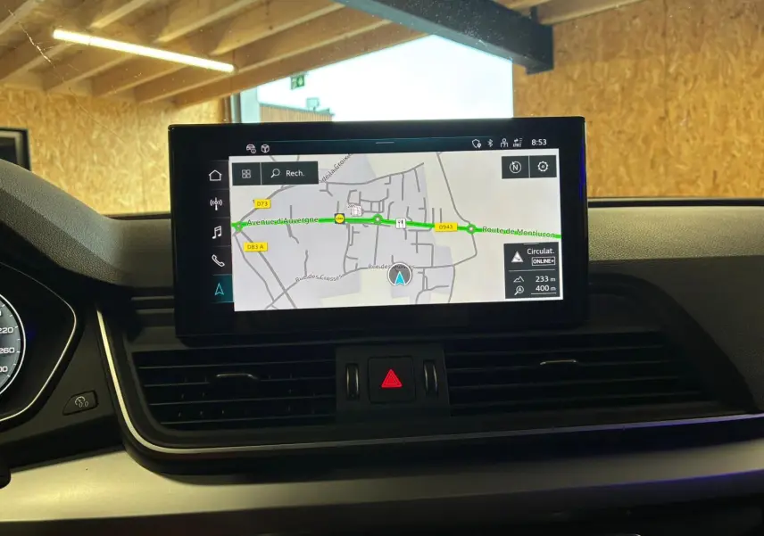 Vue intérieure centrée sur l'écran de navigation du tableau de bord de l'Audi Q5 gris 2024, affichant une carte routière.