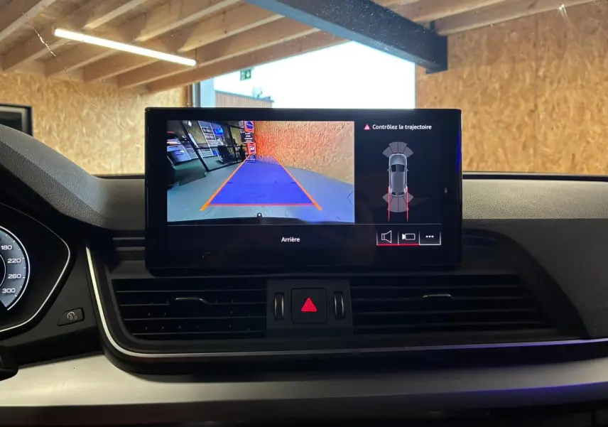 Écran central du tableau de bord d’un Audi Q5 2024 affichant la caméra de recul et l’alerte de trajectoire.