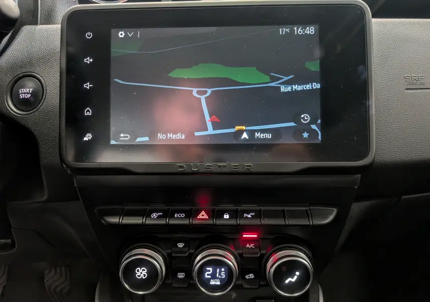 Vue rapprochée de la console centrale du Dacia Duster 2022 avec écran tactile et commandes de climatisation.