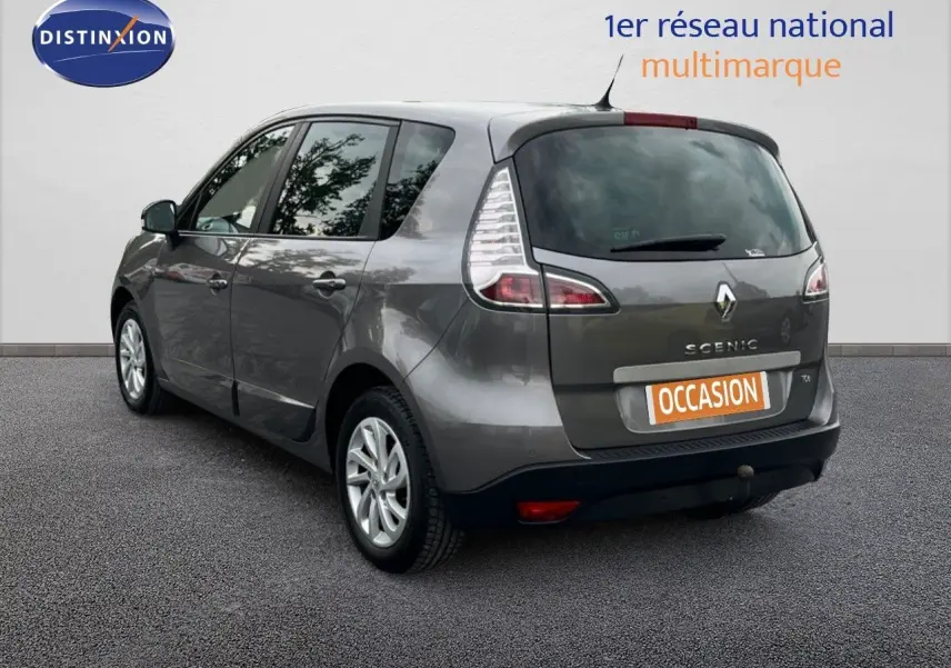 Renault Scénic III gris en 3/4 arrière gauche, avec logo et plaque "OCCASION" visible sur un fond neutre.