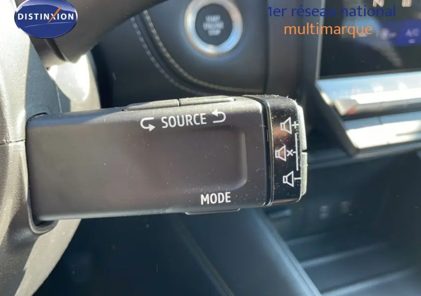 Gros plan sur la commande multimédia au volant du Renault Symbioz noir étoile métal, avec bouton source et mode visibles.