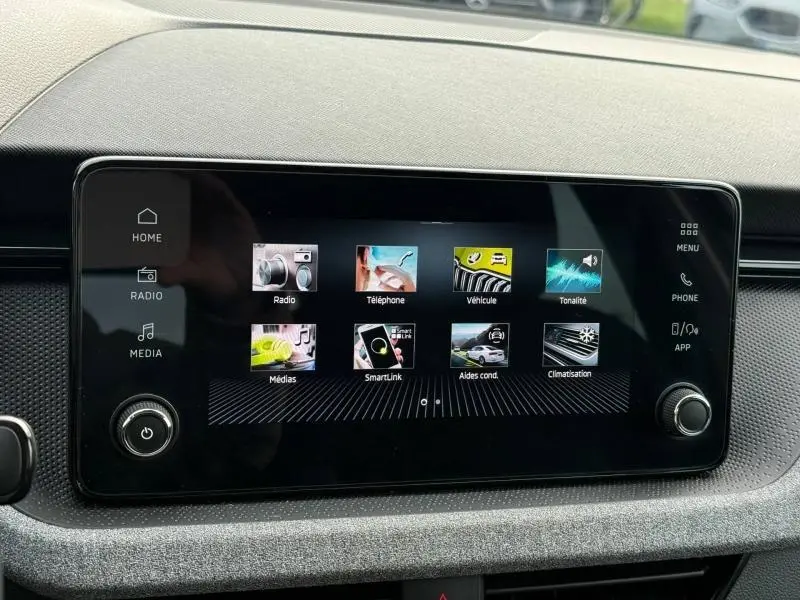 Écran tactile central du Skoda Kamiq 2024 affichant les menus radio, téléphone, véhicule et climatisation, intérieur noir.