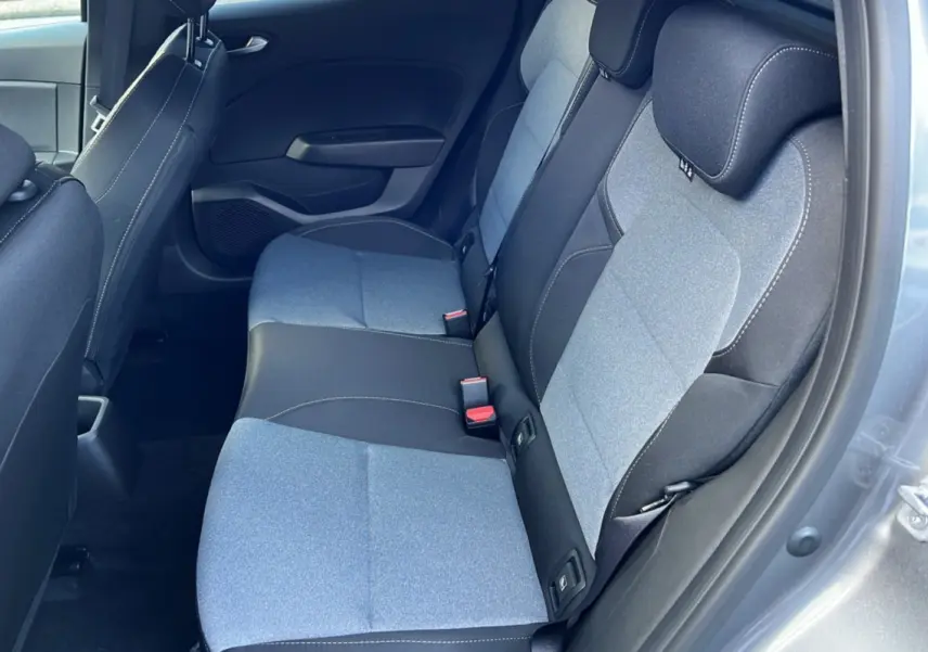 Vue intérieure sur la banquette arrière bi-ton gris clair et noir de la Renault Clio 2025, porte ouverte côté droit.